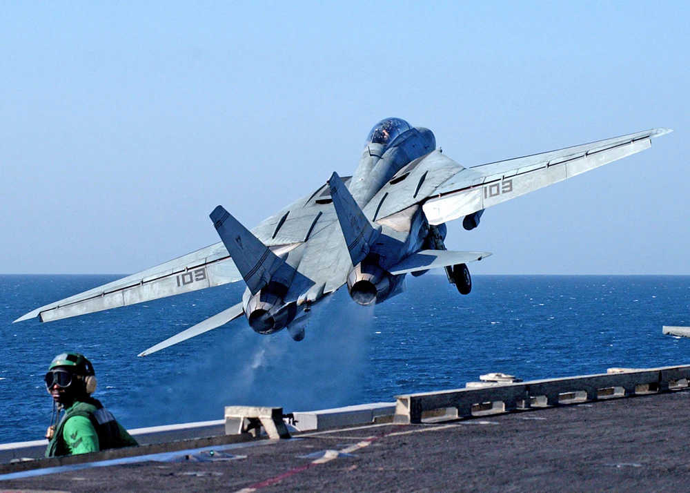 F-14 in fase di decoll dal ponte di una portaerei, si notano le ali nella massima posizione estesa.