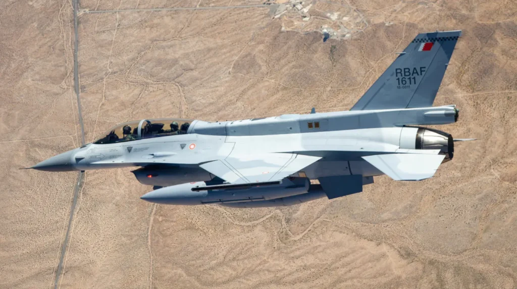 l primo esemplare biposto di nuova produzione F-16D Block 70 (matricola 1611) destinato alla Royal Bahraini Air Force ripreso in volo sopra il deserto americano. L'inquadratura ravvicinata mette in risalto la vistosa carenatura dorsale (dorsal spine), una struttura progettata per i modelli biposto avanzati che accoglie i sistemi avionici e di guerra elettronica spostati all'esterno per fare spazio al secondo membro d'equipaggio. (Foto: Lockheed Martin)