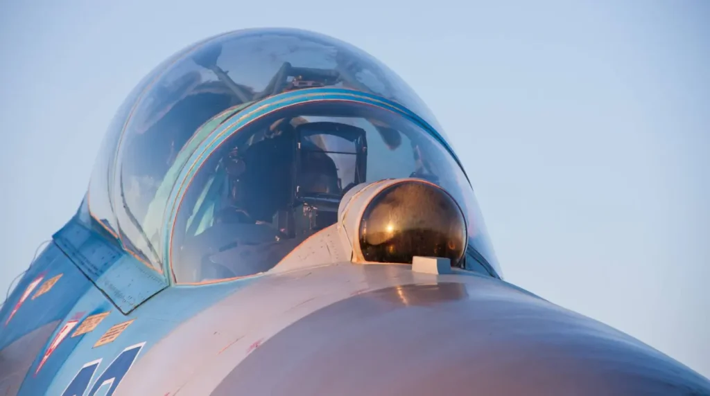 Dettaglio ravvicinato della cabina di pilotaggio di un caccia Sukhoi Flanker, che evidenzia la calotta semisferica del sistema optoelettronico di puntamento e tracciamento IRST OLS-27 sul muso (Foto: UAC)