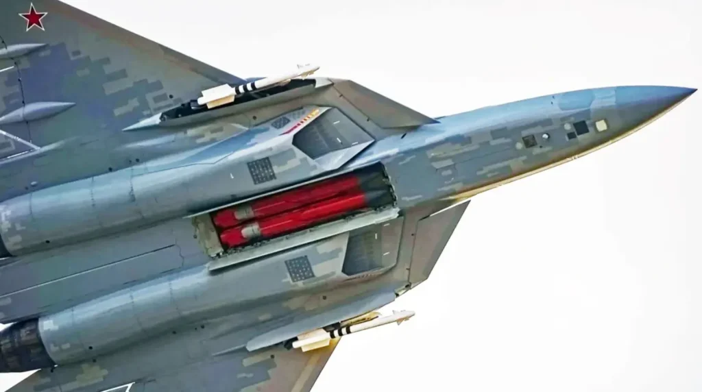 Un Sukhoi Su-57 in volo con le stive d'armamento ventrale anteriore  e laterali aperte. Al centro sono visibili due simulacri rossi di missili anti-radar a lungo raggio Kh-58USHKE, mentre le laterali contengono missili  aria-aria a corto raggio della famiglia  R-73/R-74. Foto: UAC