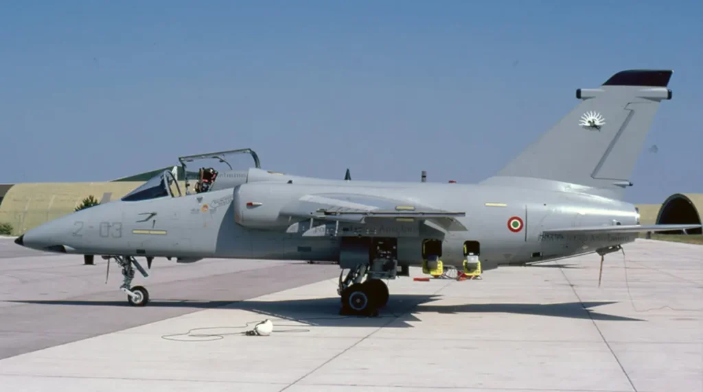 Un caccia bombardiere leggero AMX "Ghibli" monoposto (codice 2-03) del 2° Stormo dell'Aeronautica Militare Italiana parcheggiato sulla linea di volo di una base aerea.