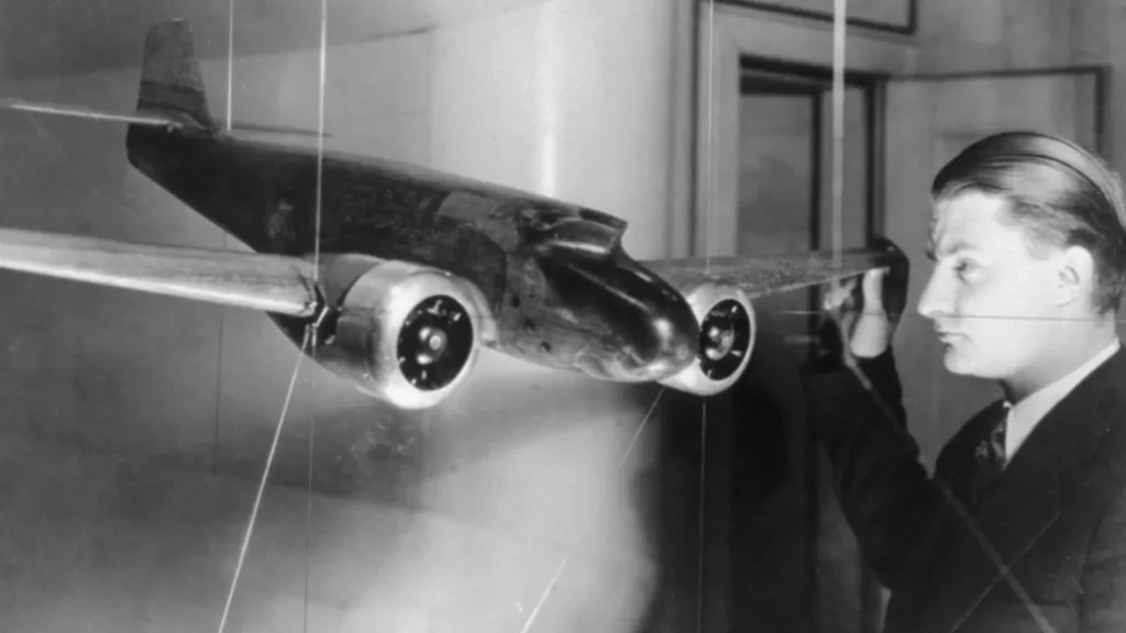 Un giovane Clarence “Kelly” Johnson con un modellino in galleria del vento di un Lockheed Electra con la sua configurazione originale a coda singola. (Università del Michigan)