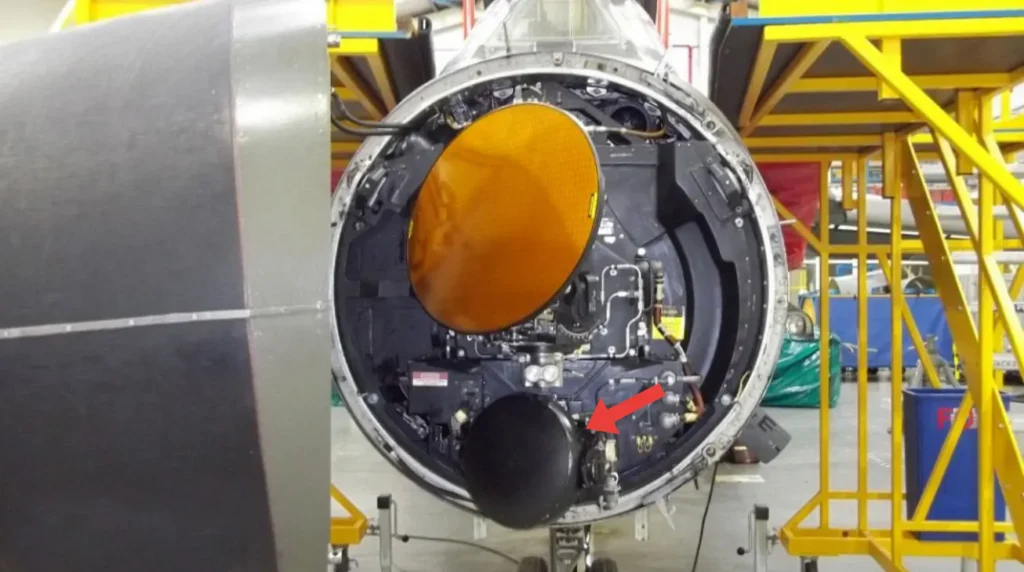 Sezione frontale aperta di un caccia Tornado GR/IDS che mostra l'antenna parabolica del radar principale e il bulbo inferiore del Terrain Following Radar TFR indicato da una freccia rossa.