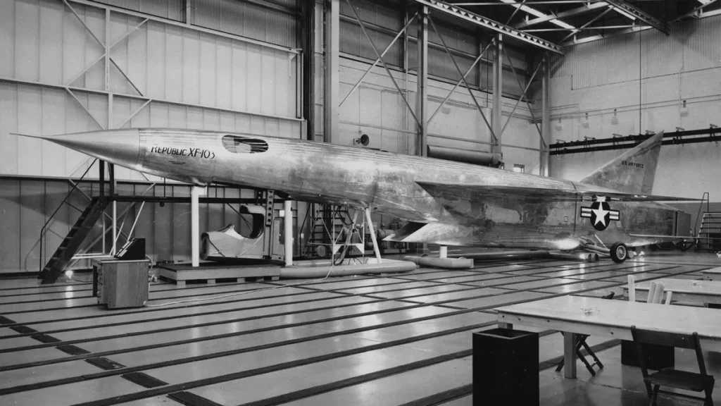 Fotografia storica d'insieme del mock-up a grandezza naturale dell'intercettore supersonico Republic XF-103 Thunderwarrior all'interno dello stabilimento di produzione.