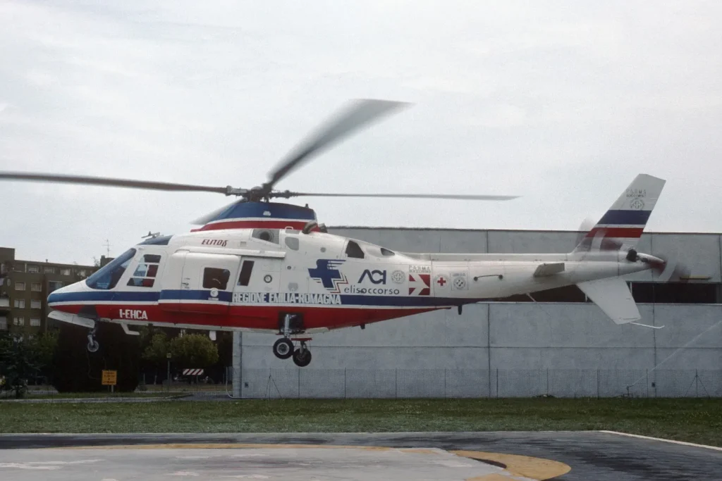  Agusta A109A II (marche I-EHCA), battezzato con il codice radio "Charlie Alpha", di proprietà della società Elitos e operato per conto di ACI Elisoccorso e della Regione Emilia-Romagna presso l'Ospedale Maggiore di Parma. Sulla fusoliera sono ben visibili i loghi storici della Regione, dell'ACI Elisoccorso e la "stella della vita" blu affiancata dallo stemma della città di Parma. Questo specifico aeromobile è tristemente noto alla storia della sanità italiana per il tragico incidente del 18 agosto 1990 sul Monte Ventasso (Reggio Emilia), nel quale persero la vita il pilota Claudio Marchini, la dottoressa Annamaria Giorgio e gli infermieri Corrado Dondi e Angelo Maffei durante una missione di soccorso.