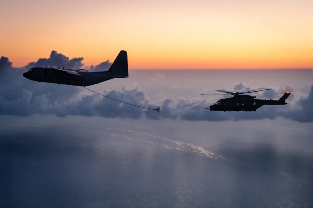 L'immagine mostra un'operazione di rifornimento in volo tra un aereo cisterna KC-130J Super Hercules della 46ª Brigata Aerea dell'Aeronautica Militare e un elicottero AgustaWestland HH-101A Caesar